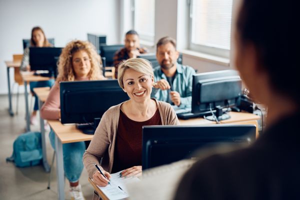 woman at computer lab learning from instructor